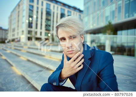 White collar worker in business suit sits near office building. 80797026
