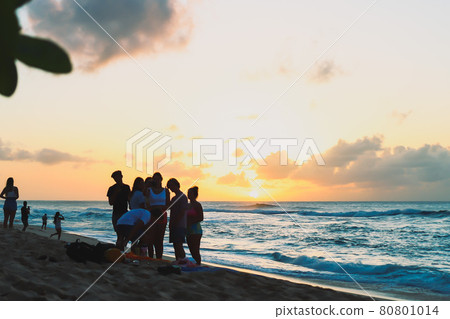 Silhouettes of young people standing at dusk in Hawaii 80801014