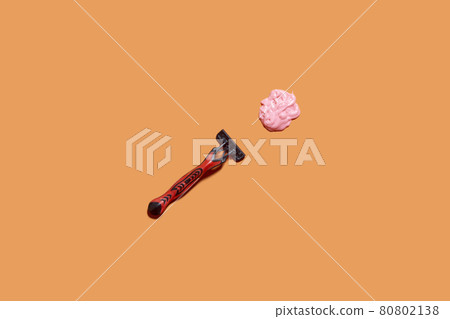Shaving foam gel and razor on orange background. A multiple use shaving razor and cream. View from above Shaving foam gel and razor on orange background. A multiple use shaving razor and cream. View from above 80802138