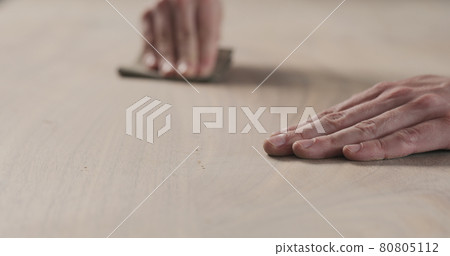 man hand sanding black walnut wood table 80805112