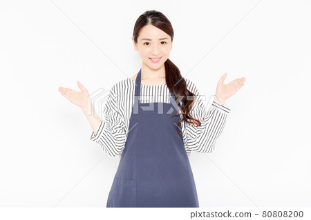 一個穿著圍裙的女人做引導手勢 一個穿著圍裙的女人做引導手勢 80808200