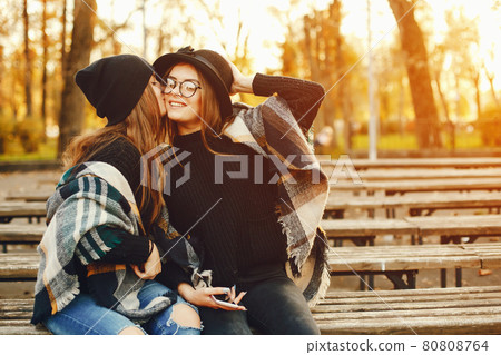 two young girls walk around the city in the autumn city and park two young girls walk around the city in the autumn city and park 80808764