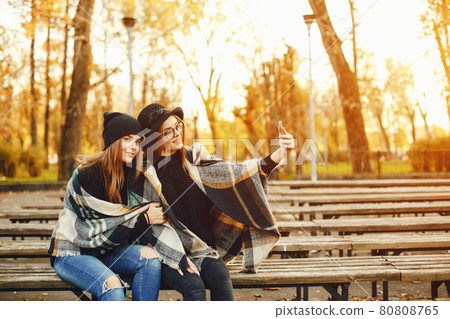 two young girls walk around the city in the autumn city and park two young girls walk around the city in the autumn city and park 80808765