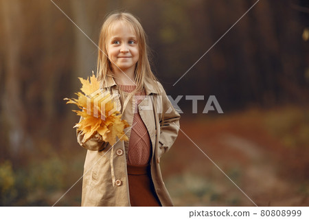 Cute little girl walks in a autumn park Cute little girl walks in a autumn park 80808999