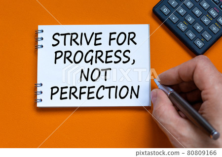 Progress or perfection symbol. Businessman writing words Strive for progress, not perfection on white note. Black calculator. Orange background. Business, progress or perfection concept. Copy space. Progress or perfection symbol. Businessman writing words Strive for progress, not perfection on white note. Black calculator. Orange background. Business, progress or perfection concept. Copy space. 80809166