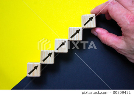 Business concept growth success process. Wood block stacking as step stair on paper yellow and black background, male hand. Copy space. Business concept growth success process. Wood block stacking as step stair on paper yellow and black background, male hand. Copy space. 80809451