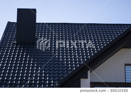 Grey corrugated metal profile roof installed on a modern house. The roof of corrugated sheet. Roofing of metal profile wavy shape. Modern roof made of metal. Metal roofing. Grey corrugated metal profile roof installed on a modern house. The roof of corrugated sheet. Roofing of metal profile wavy shape. Modern roof made of metal. Metal roofing. 80810398