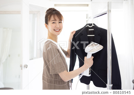 Young woman ironing a jacket Young woman ironing a jacket 80810545