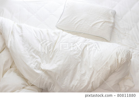 Disordered duvets and pillows on the bed Disordered duvets and pillows on the bed 80811880