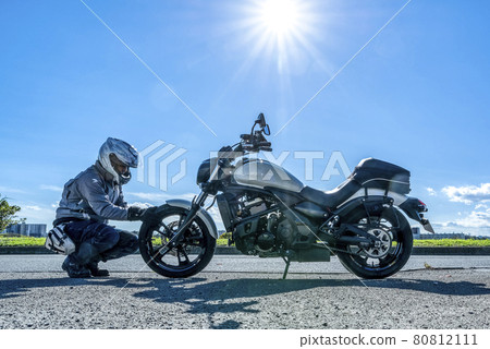 Sunny day touring Rider checking tires before touring Sunny day touring Rider checking tires before touring 80812111