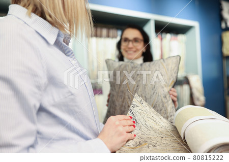 Woman chooses fabric for sewing pillows closeup 80815222