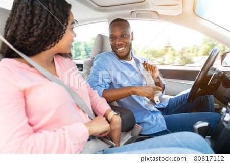 Happy African American Couple Putting On Seatbelts Happy African American Couple Putting On Seatbelts 80817112