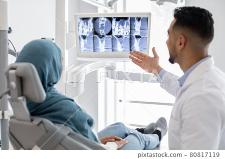 Arab Male Dentist Showing Treatment Result At Teeth Xray To Muslim Patient Arab Male Dentist Showing Treatment Result At Teeth Xray To Muslim Patient 80817119