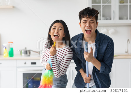 Happy asian guy cleaning apartment with his girlfriend Happy asian guy cleaning apartment with his girlfriend 80817161