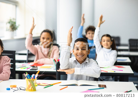 Happy little school children raising hands at classroom Happy little school children raising hands at classroom 80817213
