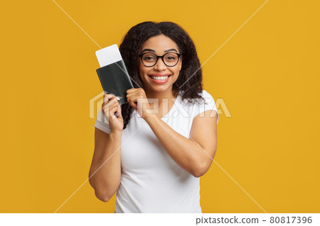Excited african american woman tourist with passport and flight tickets getting ready for vacation, yellow background Excited african american woman tourist with passport and flight tickets getting ready for vacation, yellow background 80817396