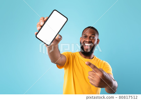 New awesome mobile app. Black guy pointing at smartphone with blank screen on blue background, mockup 80817512