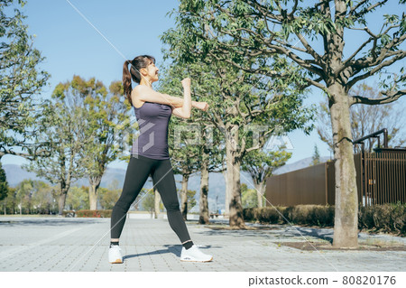 Woman (arm) preparing for exercise in the park Woman (arm) preparing for exercise in the park 80820176