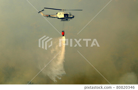 A helicopter extinguishes a fire in the mountains on the border between Israel and Lebanon 80820346