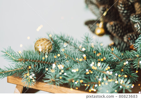 Branch of Christmas tree with bauble on the background of cones Branch of Christmas tree with bauble on the background of cones 80823683