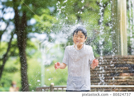 Boy bathing in water from his head 80824737