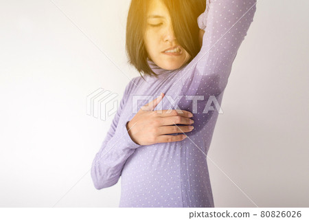 Asian woman with odor sweating,Female smelling or sniffing her armpit,Bad smell,Copy space for text and white background 80826026