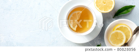 Lemon tea in a cup panorama, overhead flat lay shot. Organic lemons 80828056