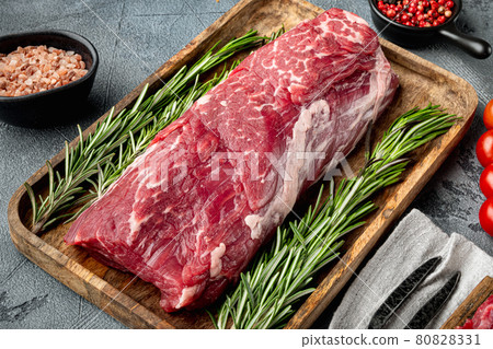 Fresh Raw Beef steak Mignon, with salt, peppercorns, thyme, garlic Ready to cook, on gray stone background Fresh Raw Beef steak Mignon, with salt, peppercorns, thyme, garlic Ready to cook, on gray stone background 80828331