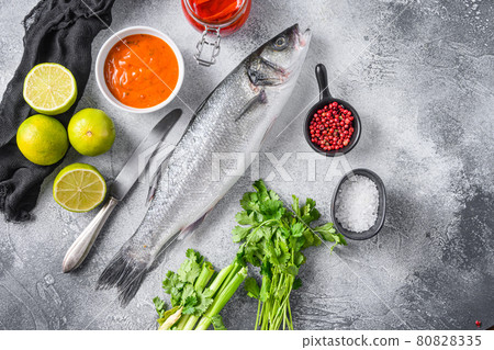 Raw seabass with spices and herbs ingredients on grey concrete background top view spacr for text. Raw seabass with spices and herbs ingredients on grey concrete background top view spacr for text. 80828335