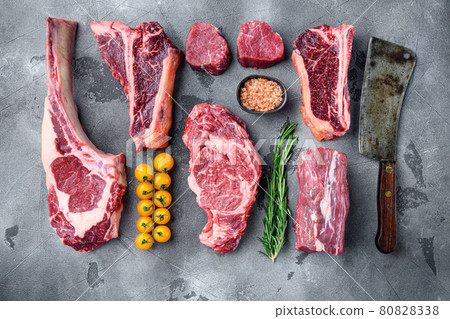 Raw beef meat steaks, tomahawk, t bone, club steak, rib eye and tenderloin cuts, on gray stone background, top view flat lay Raw beef meat steaks, tomahawk, t bone, club steak, rib eye and tenderloin cuts, on gray stone background, top view flat lay 80828338