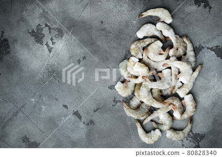Frozen raw uncooked tiger prawns, shrimps, on gray stone background, top view flat lay, with copy space for text Frozen raw uncooked tiger prawns, shrimps, on gray stone background, top view flat lay, with copy space for text 80828340