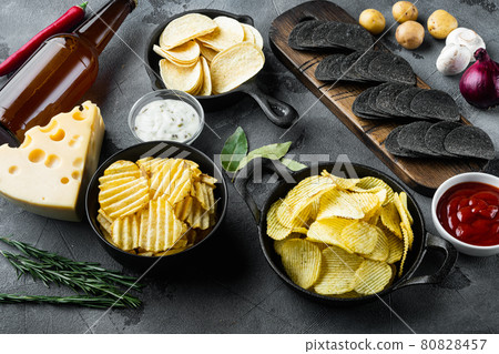 Potato chips. Beer snacks, sauce with Cheese and Onion, with dipping sauces , on gray stone background Potato chips. Beer snacks, sauce with Cheese and Onion, with dipping sauces , on gray stone background 80828457