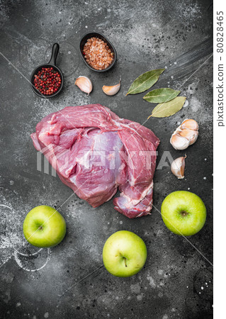 Raw meat, piece of pork with seasonings, on black dark stone table background, top view flat lay Raw meat, piece of pork with seasonings, on black dark stone table background, top view flat lay 80828465