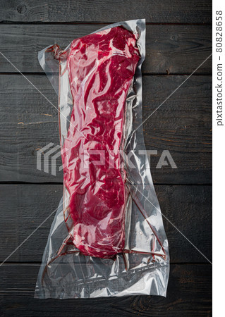 Sirloin beef steak in vacuum packaging. Market pack, on black wooden table background, top view flat lay Sirloin beef steak in vacuum packaging. Market pack, on black wooden table background, top view flat lay 80828658