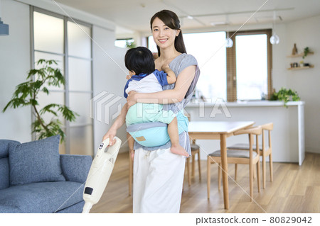 一位母親抱著一歲半的兒子在打掃衛生 80829042