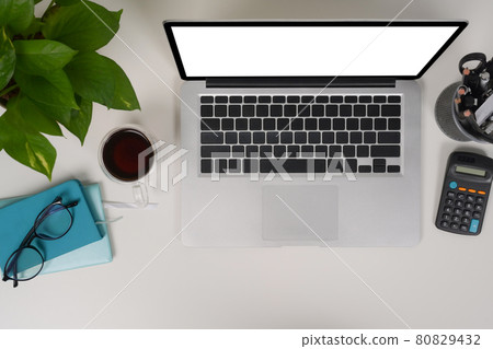 Above view laptop computer, calculator, houseplant and coffee cup on white desk. 80829432