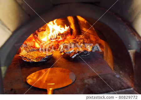 Homemade pizza baked in a stone oven at a campsite 80829772