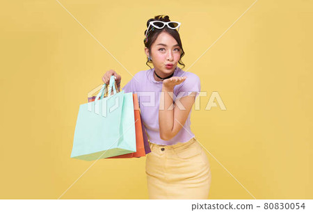 Cheerful happy teen asian woman enjoying shopping, she is carrying shopping bags at the shopping center. Cheerful happy teen asian woman enjoying shopping, she is carrying shopping bags at the shopping center. 80830054
