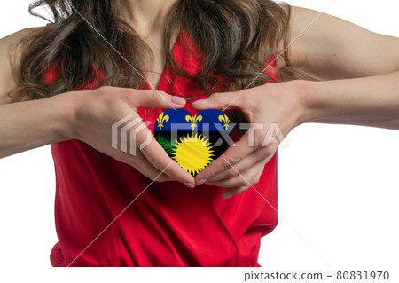 Love Guadeloupe. The woman holds a heart in the form of the flag of Guadeloupe on her chest. Concept of patriotism Love Guadeloupe. The woman holds a heart in the form of the flag of Guadeloupe on her chest. Concept of patriotism 80831970