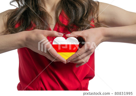 Love South Ossetia. The woman holds a heart in the form of the flag of South Ossetia on her chest. Concept of patriotism Love South Ossetia. The woman holds a heart in the form of the flag of South Ossetia on her chest. Concept of patriotism 80831995