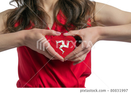 Love Isle of Man. The woman holds a heart in the form of the flag of Isle of Man on her chest. Concept of patriotism 80831997
