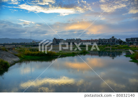 河面上，雲朵出現在天線上，陽光明媚，水面上出現美麗的心齋倒影。 80832140