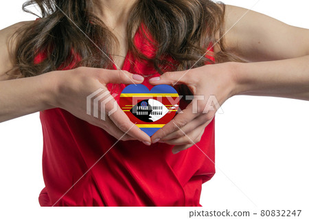 Love Esvatini The woman holds a heart in the form of the flag of Esvatini on her chest. Concept of patriotism Love Esvatini The woman holds a heart in the form of the flag of Esvatini on her chest. Concept of patriotism 80832247