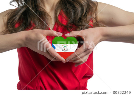 Love Equatorial Guinea The woman holds a heart in the form of the flag of Equatorial Guinea on her chest. Concept of patriotism Love Equatorial Guinea The woman holds a heart in the form of the flag of Equatorial Guinea on her chest. Concept of patriotism 80832249