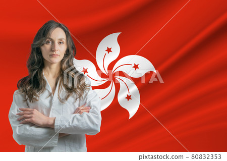 Medicine in Hong Kong. Happy beautiful female doctor in medical coat standing with crossed arms against the background of the flag of Hong Kong Medicine in Hong Kong. Happy beautiful female doctor in medical coat standing with crossed arms against the background of the flag of Hong Kong 80832353