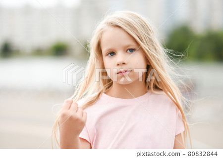 Portrait of a little girl in a pink shirt on the street Portrait of a little girl in a pink shirt on the street 80832844