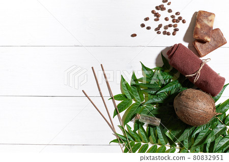 Natural handmade soaps with coffee beans, brown towel, coconut and green leaves on white wooden background Natural handmade soaps with coffee beans, brown towel, coconut and green leaves on white wooden background 80832951