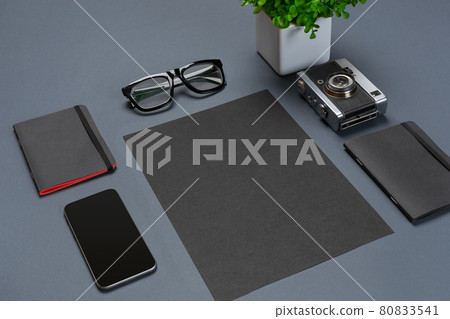 A set of black office accessories, glasses, green flower and smart on gray background A set of black office accessories, glasses, green flower and smart on gray background 80833541