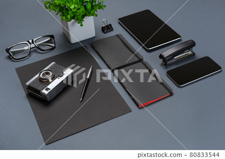 A set of black office accessories, glasses, old camera and tablet on gray background A set of black office accessories, glasses, old camera and tablet on gray background 80833544