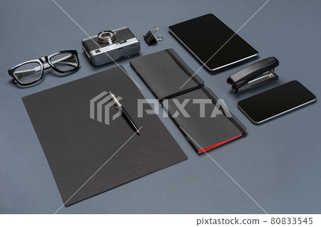 A set of black office accessories, glasses, old camera and tablet on gray background A set of black office accessories, glasses, old camera and tablet on gray background 80833545